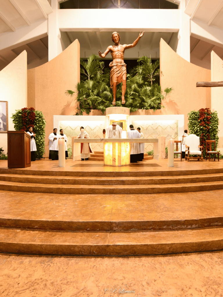 Peaceful church altar with religious statues, priests, and congregants during a ceremony.