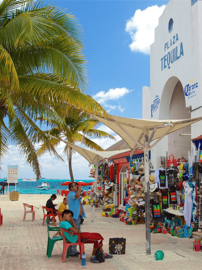 Colorful beach souvenirs at Playa Tequila, with palm trees and stunning ocean views. Perfect for vacation shopping.