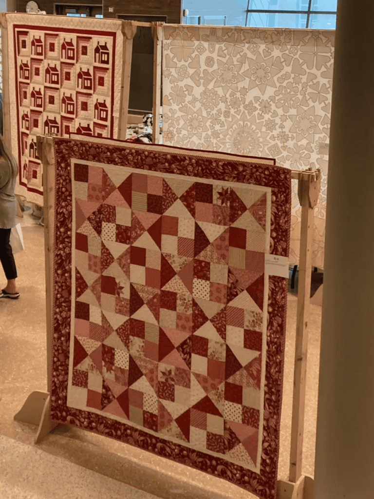 Vintage quilt display showcasing intricate patchwork designs for textile art enthusiasts.