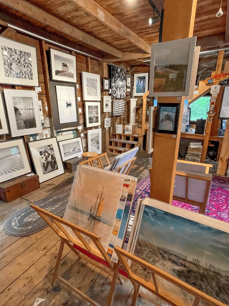 Bright art gallery with framed black-and-white and color landscape and abstract photos in rustic wooden interior.