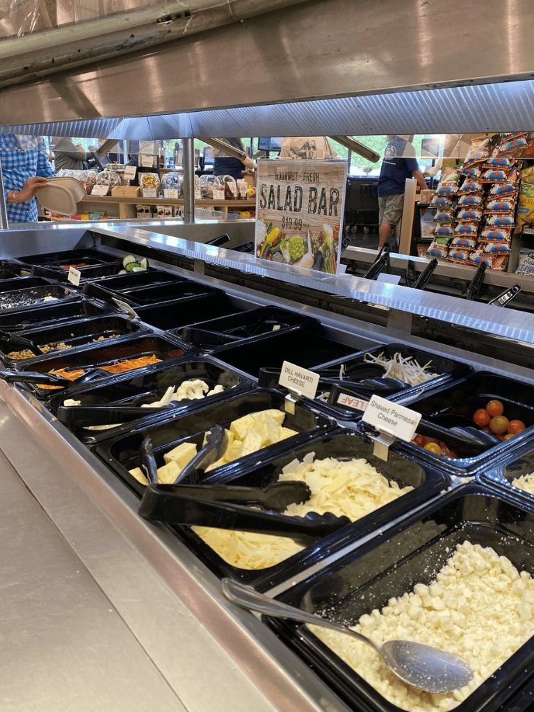 Butcher block deli with fresh cheeses and salads at QuestForDirections grocery store.