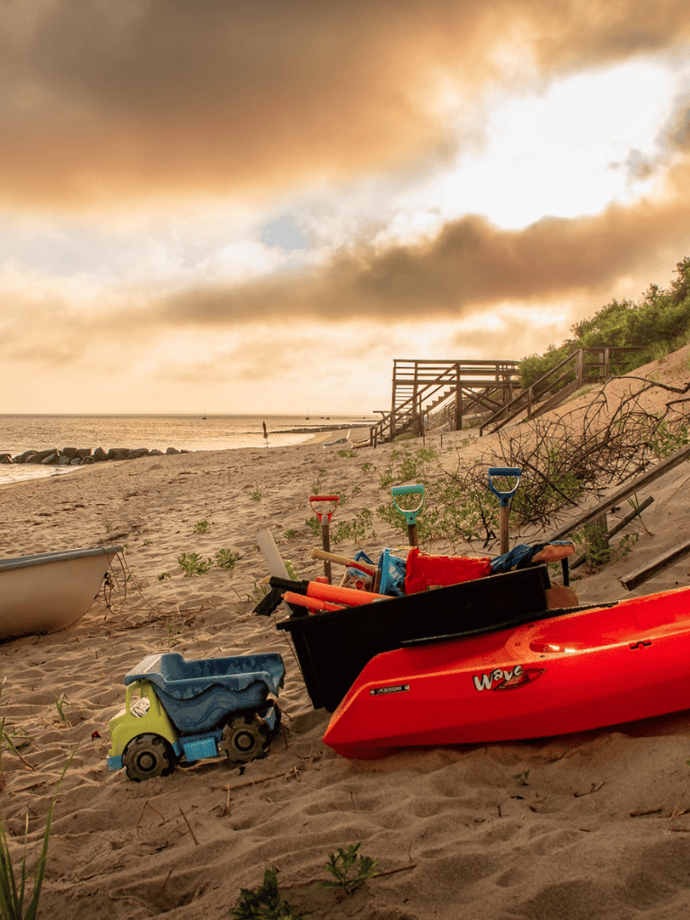Beach with sand toys and shoreline at sunset, scenic coastal view, vacation, family fun, outdoor activities.
