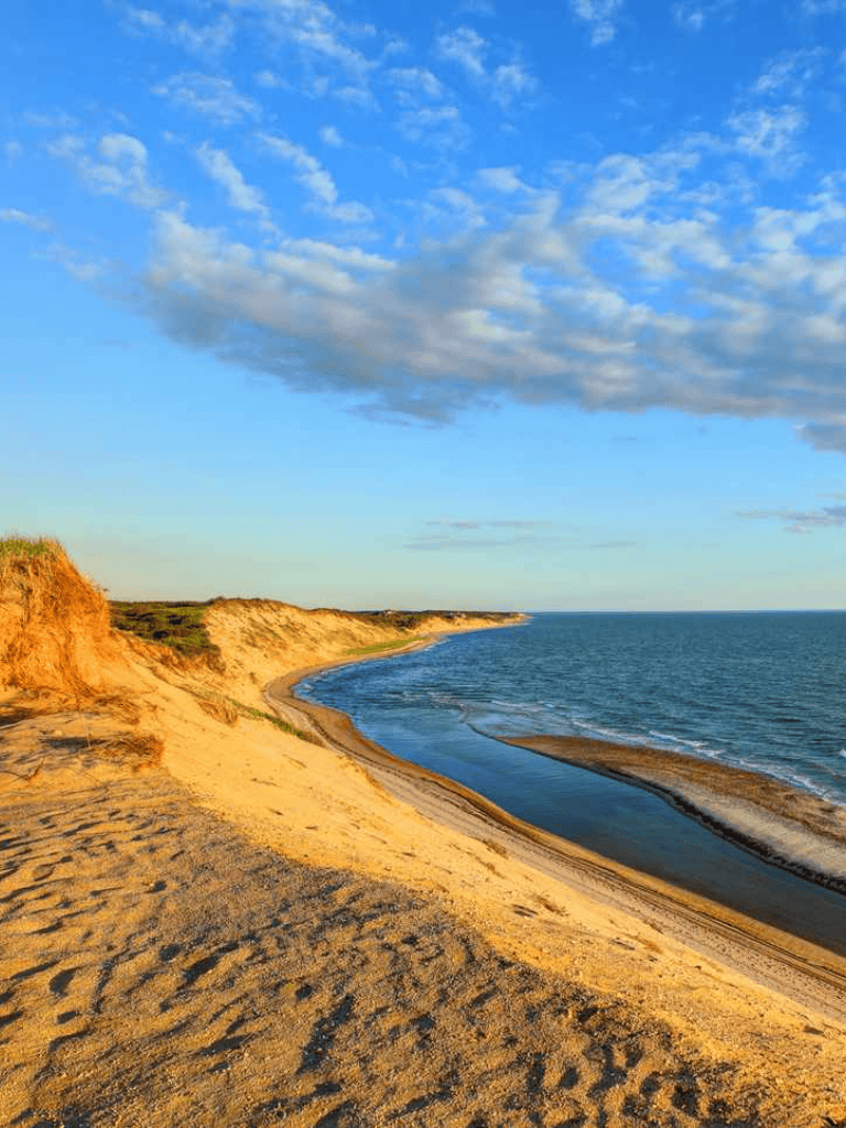 Cliffside beach with golden sands and ocean view at sunset, scenic coastal landscape for outdoor adventures.