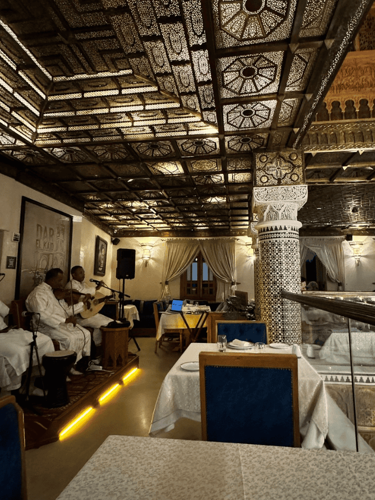 Elegant Moroccan restaurant interior with live traditional music performance.