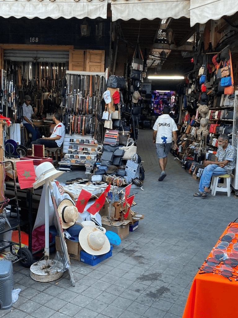 Colorful street market stall selling accessories, bags, hats, and sunglasses. Vibrant marketplace for fashion accessories.