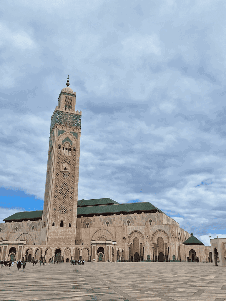 Majestic Moroccan mosque with towering minaret and intricate tile work.