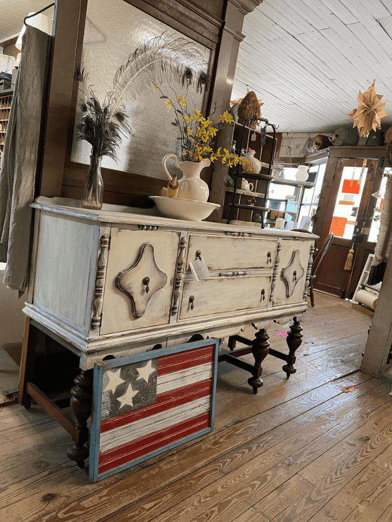 Vintage distressed cream sideboard with decorative hardware and patriotic Americana decor at QuestForDirections.