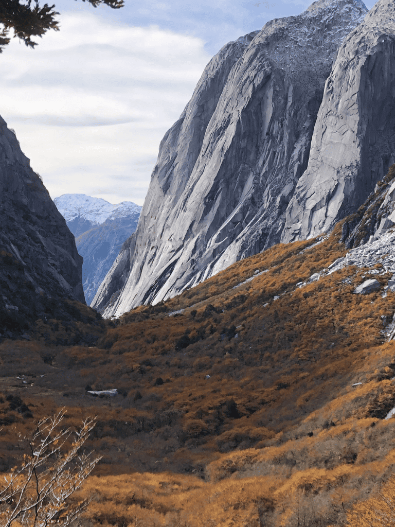 Stunning mountain valley with rugged cliffs and autumn-colored foliage for outdoor adventure.