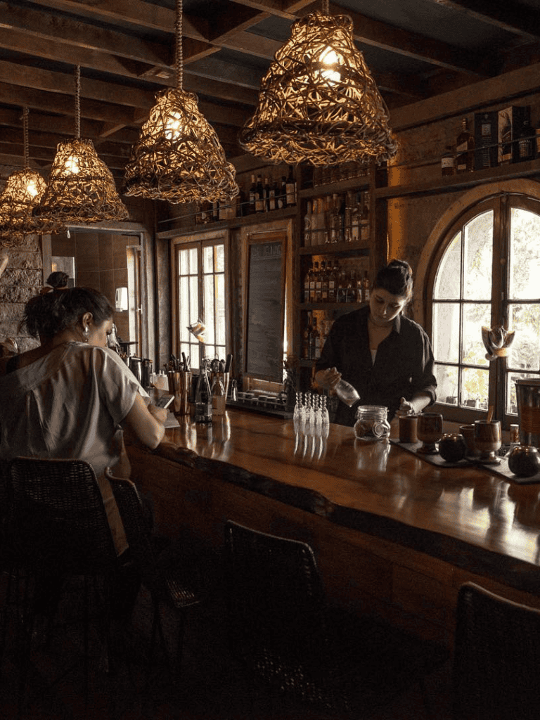 Cozy bar interior with warm lighting and wooden accents, inviting ambiance for drinks and relaxation.