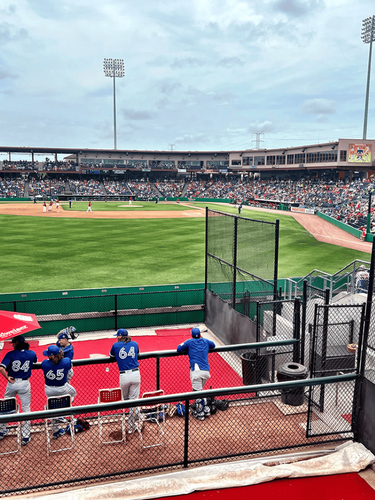 Players warming up at a baseball stadium during a game or practice session.