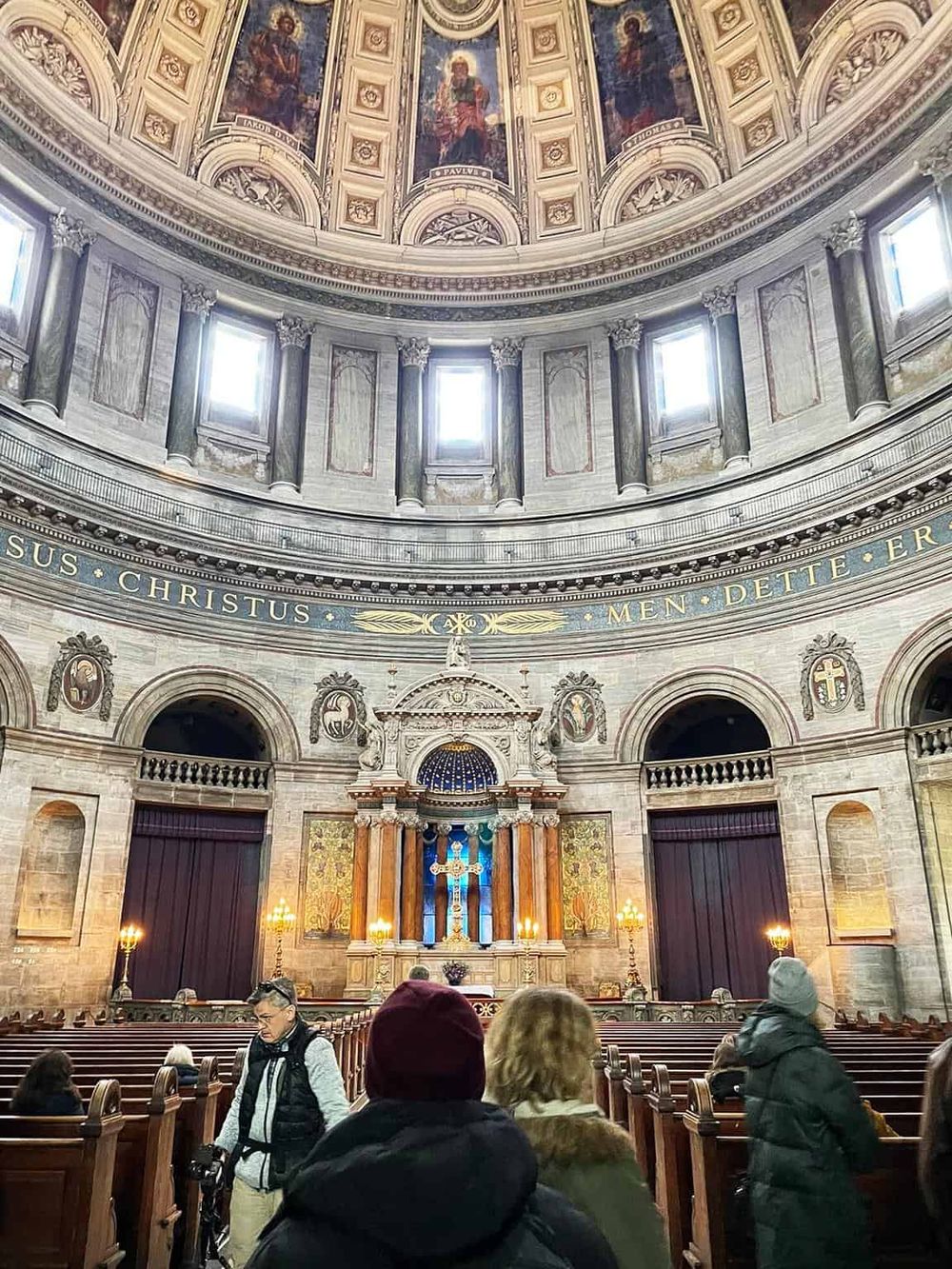 Magnificent church interior with high domed ceiling and ornate altar, showcasing historic architecture.