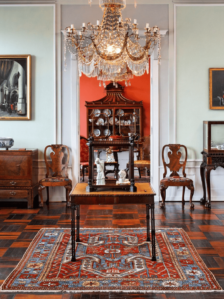 Elegant antique chandelier in a historic interior with ornate furniture and vintage decor.