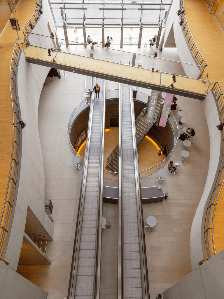 1. Modern multi-level shopping mall interior with escalators and seating areas.