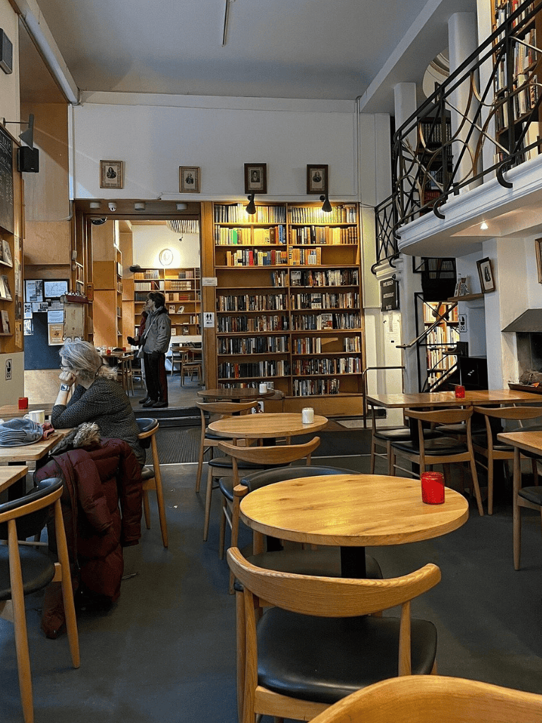 Cozy bookstore café with wooden tables and bookshelves, ideal for reading and relaxing.