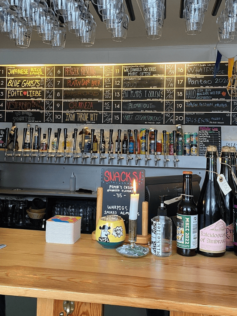 Colorful beer taps and a chalkboard menu at a cozy bar in QuestForDirections. Perfect place for craft beer enthusiasts and social gatherings.