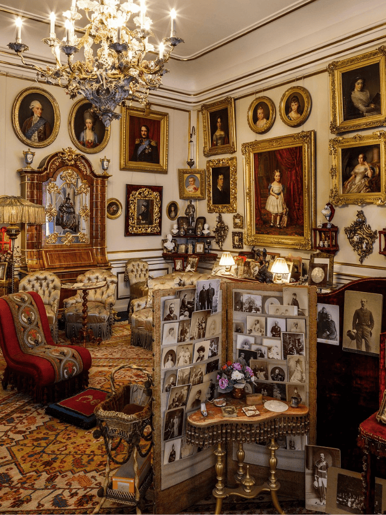 Antique vintage portrait collection in elegant Victorian-style interior with ornate paintings and chandelier.