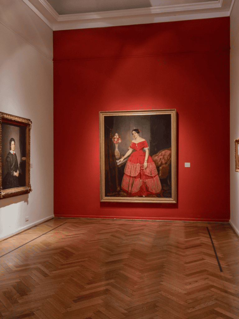 Elegant art gallery with classic portraits and ornate frames, showcasing cultural and artistic exploration.