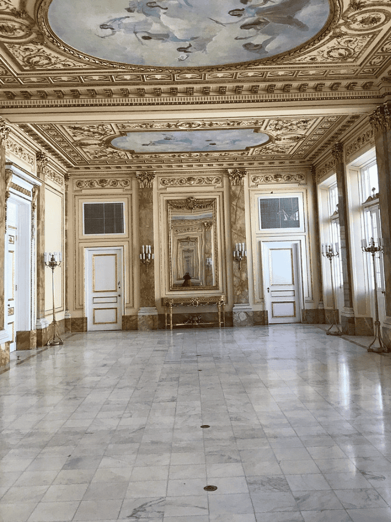 Elegant historic palace interior with ornate ceiling and classical decor.