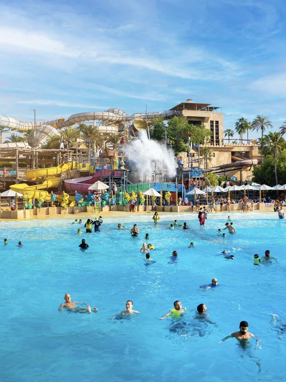 Water park with multiple water slides and a large pool, family-friendly outdoor water attraction.