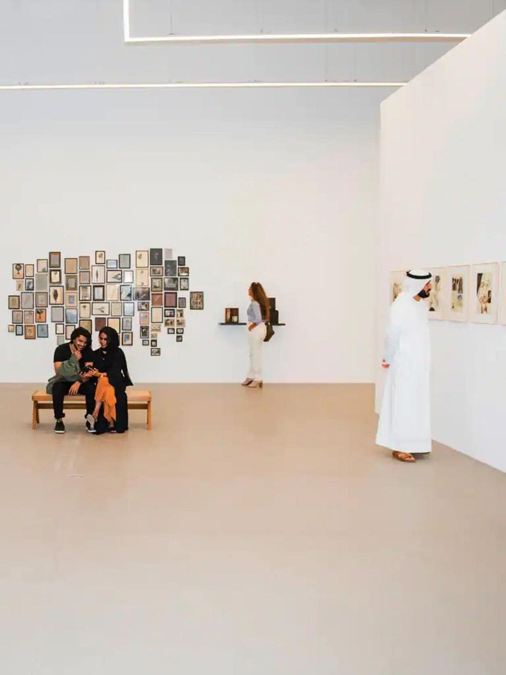 Modern art gallery with visitors viewing artwork and engaging with exhibits.