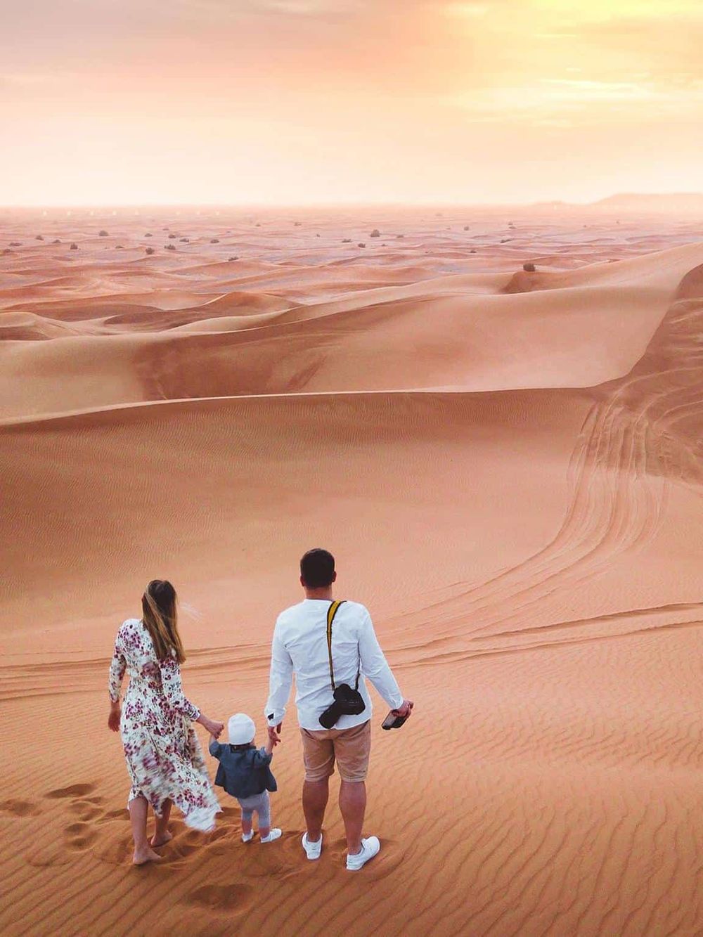 Vast desert landscape with family exploring sand dunes, capturing adventure and travel experiences.