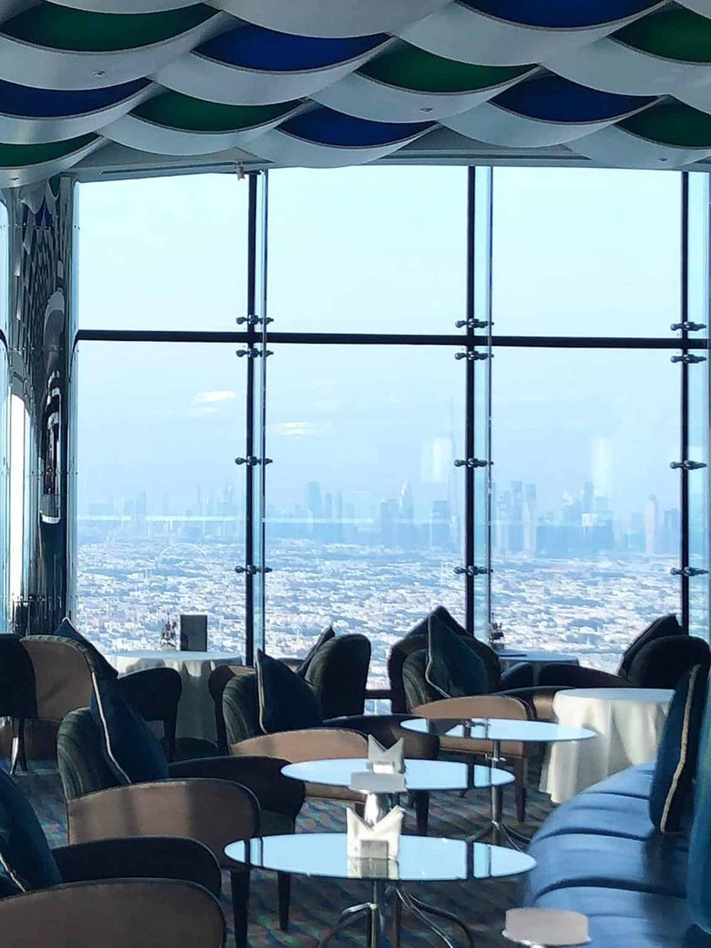 Stunning city view from a high-rise lounge with modern furnishings and panoramic glass windows.