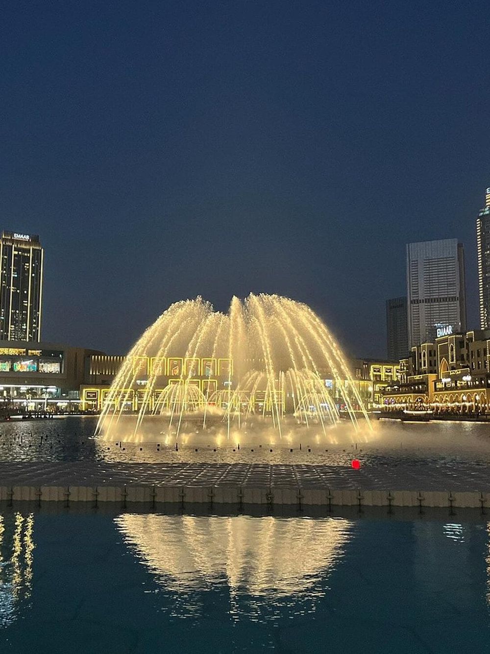 Elegant city fountain illuminated at night in Dubai's downtown skyline, showcasing modern urban design.