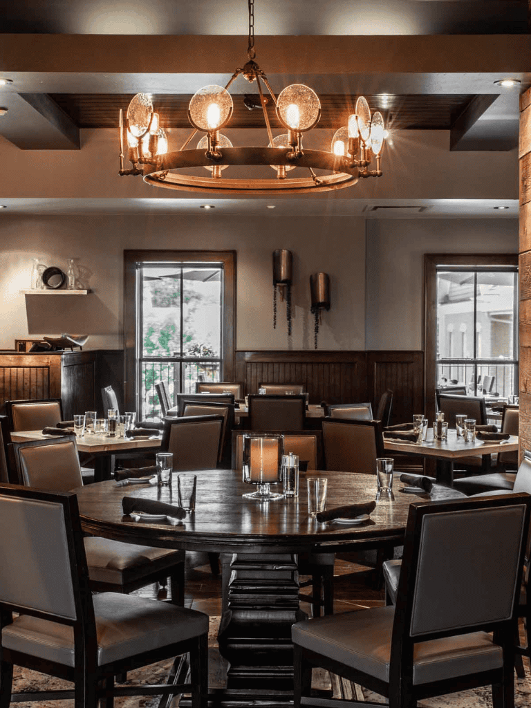 Elegant restaurant interior with wooden furniture, soft lighting, and modern decor for fine dining experiences.