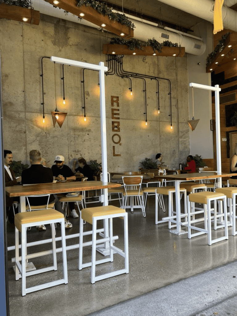 Modern coffee shop interior with industrial design and cozy seating.