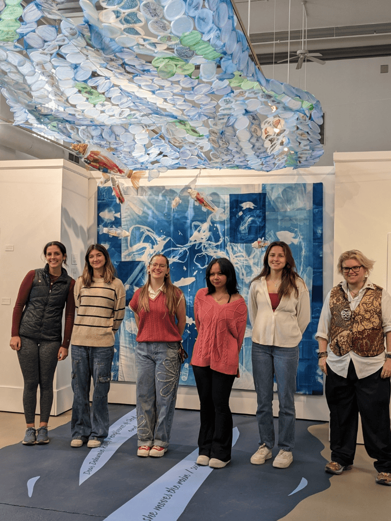 Vibrant underwater-themed art installation featuring floating fish sculptures at QuestForDirections exhibit.