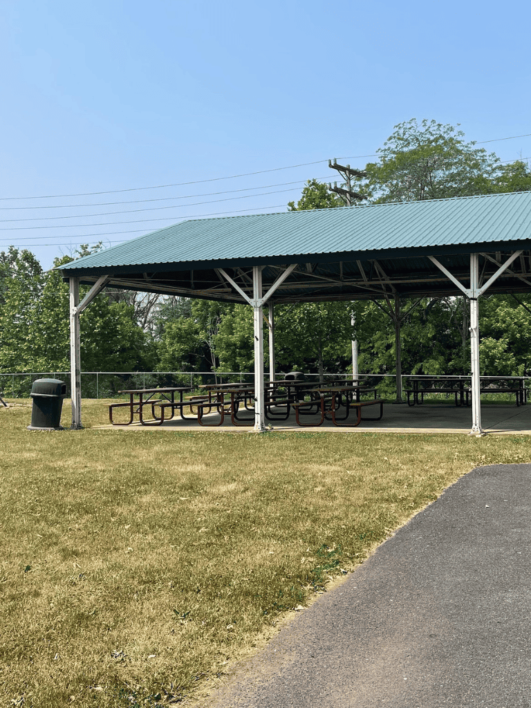 Open-air picnic shelter with tables at Quest for Directions park.