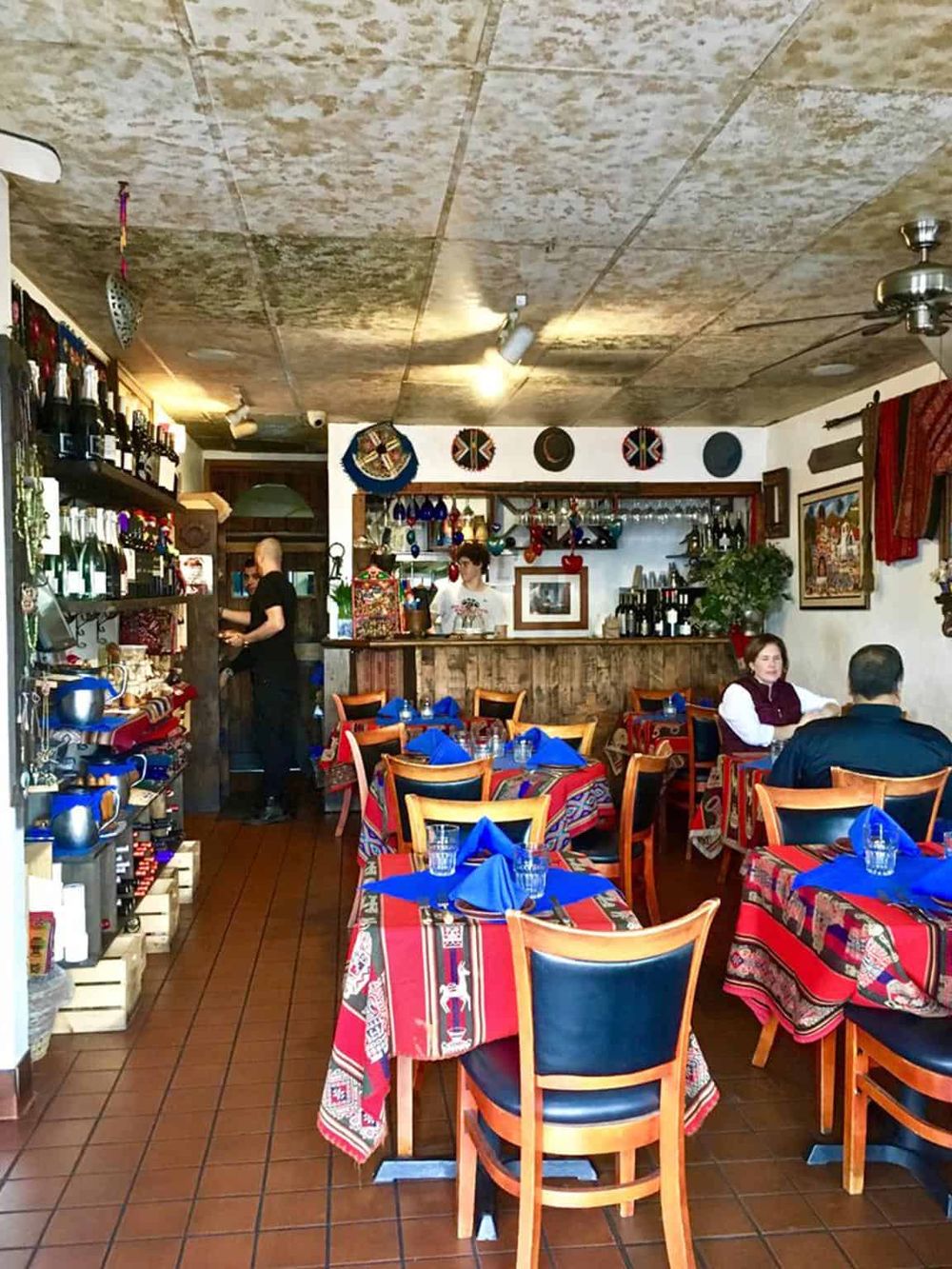 Colorful cozy restaurant with traditional decor, vibrant table settings, and friendly staff, offering authentic culinary experiences.