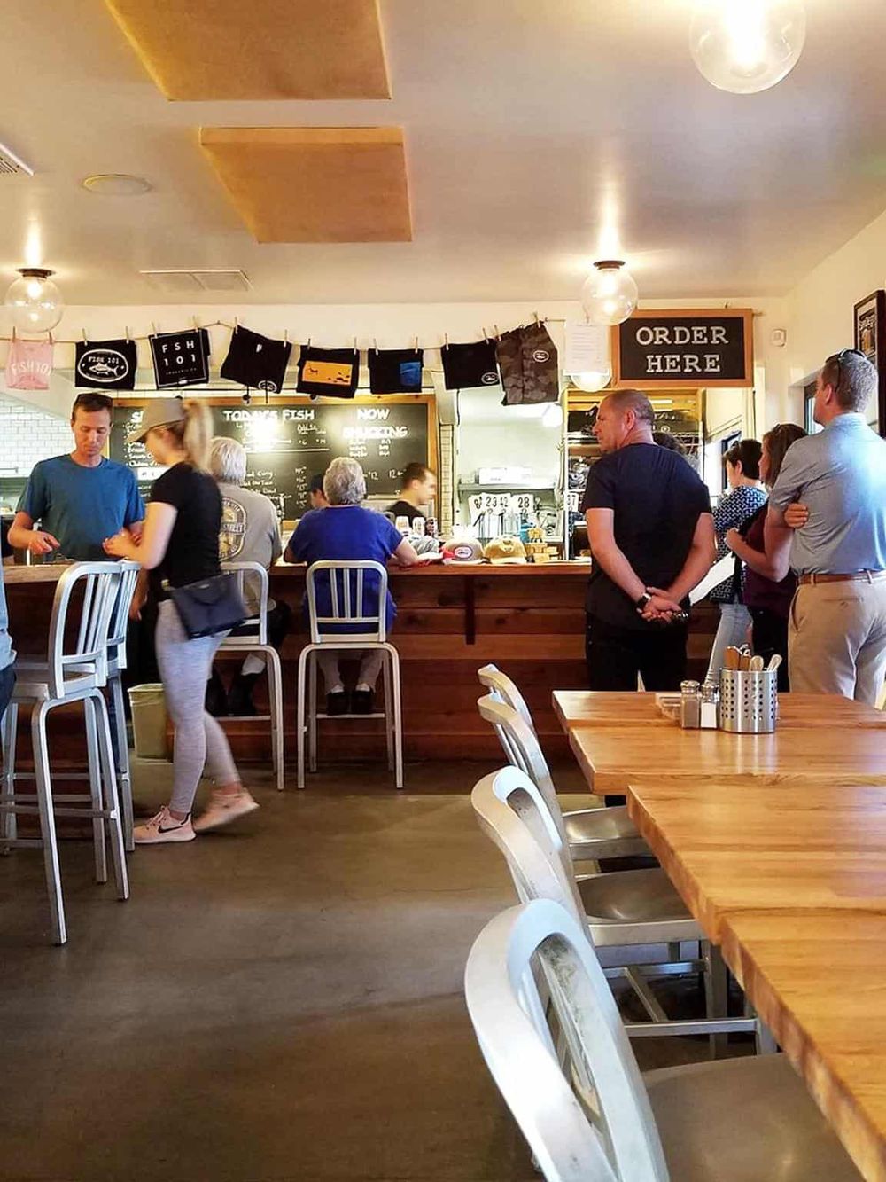 Cozy seafood restaurant interior with customers ordering at the counter and dining area, perfect for seafood lovers and casual dining.