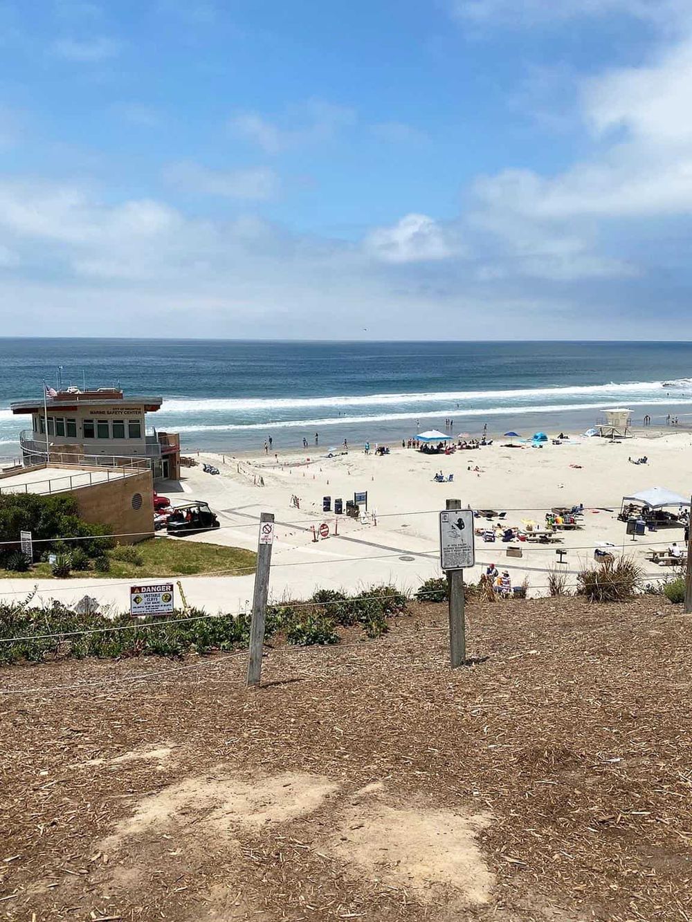Bright sunny day at the beach showing clear blue skies and relaxing ocean waves.