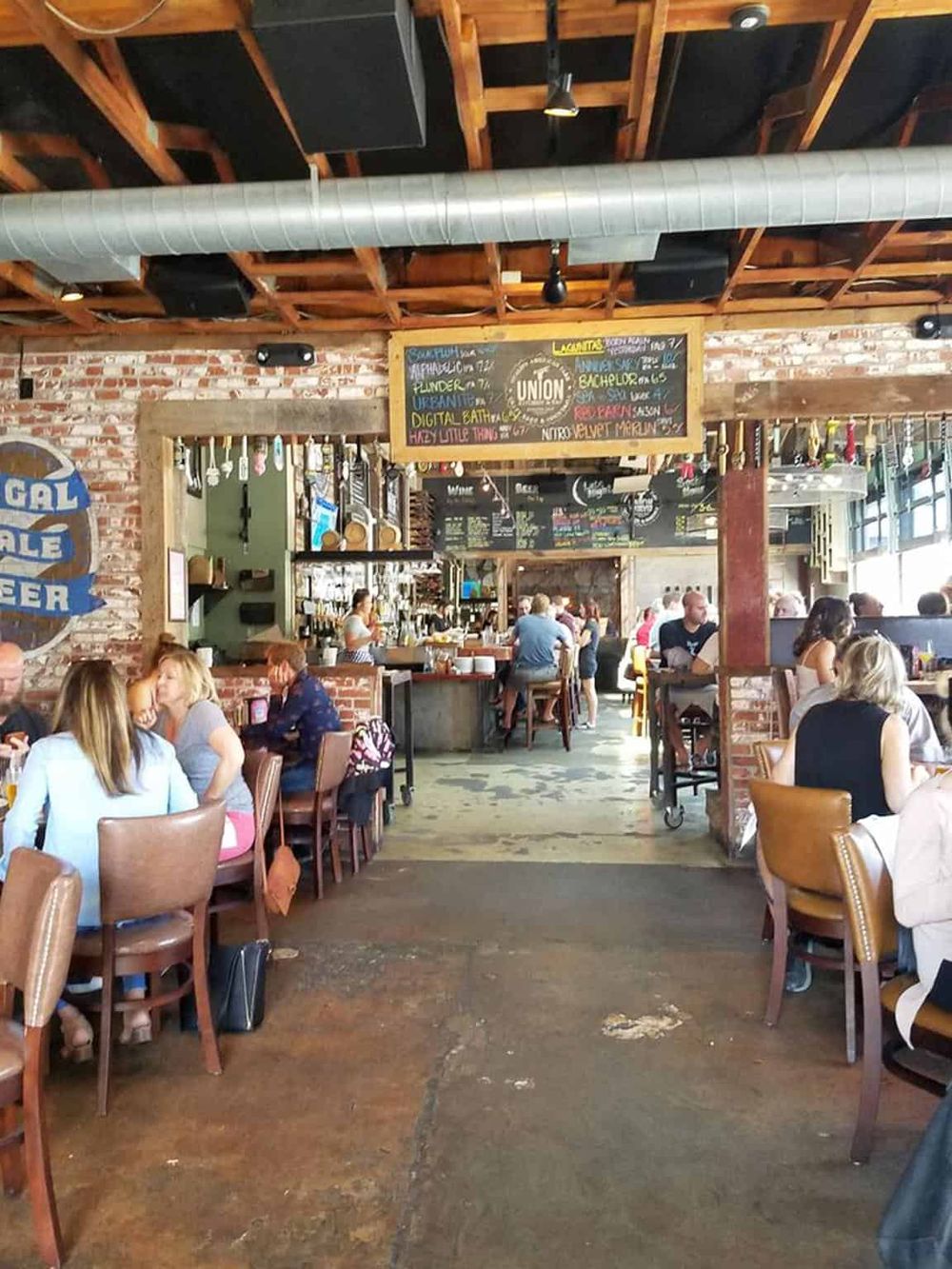 Cozy urban restaurant interior with brick walls, wooden accents, and modern decor, perfect for casual dining and socializing.