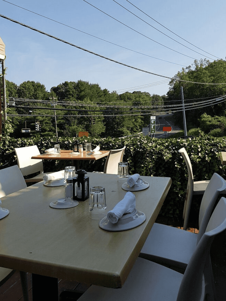 Outdoor restaurant dining with scenic view and greenery. Perfect for relaxing meals and social gatherings.