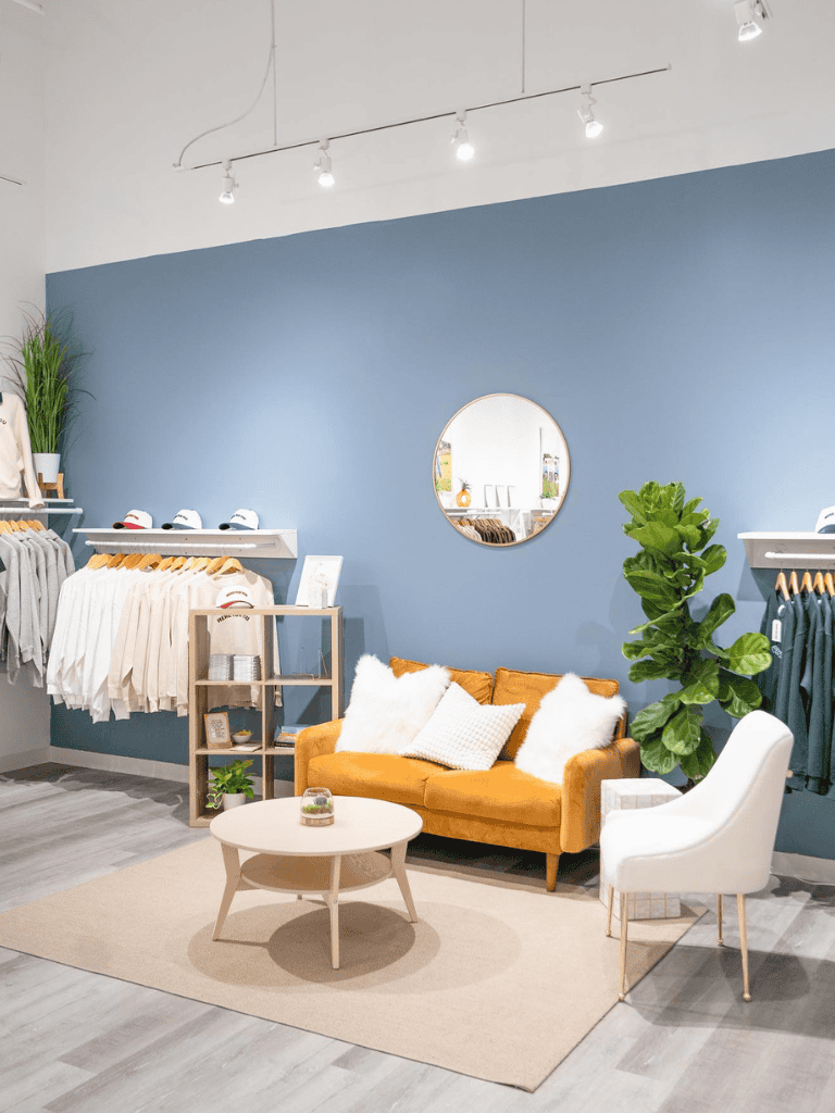 Cozy boutique clothing store with comfortable seating, stylish decor, and organized apparel displays.
