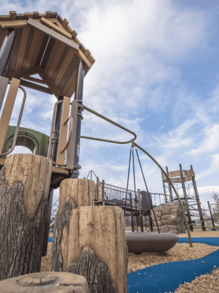 Enchanted playground with wooden climbing structures and slides, ideal for children's outdoor fun and adventure.