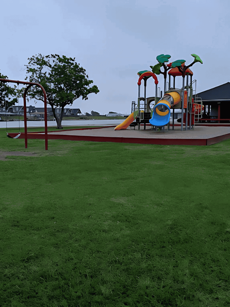 Colorful playground with slides and swings in a park setting for children’s outdoor fun.