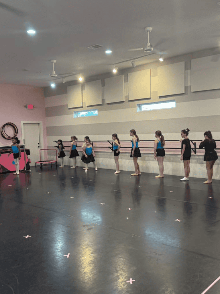 Young ballet dancers practicing at dance studio with mirror and ballet barres for dance training.