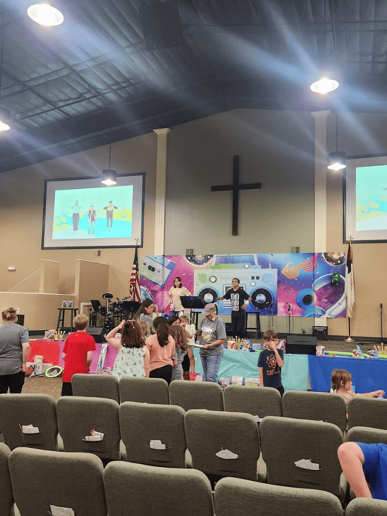 Joyful church event with kids, music, and colorful decor in a spacious sanctuary.