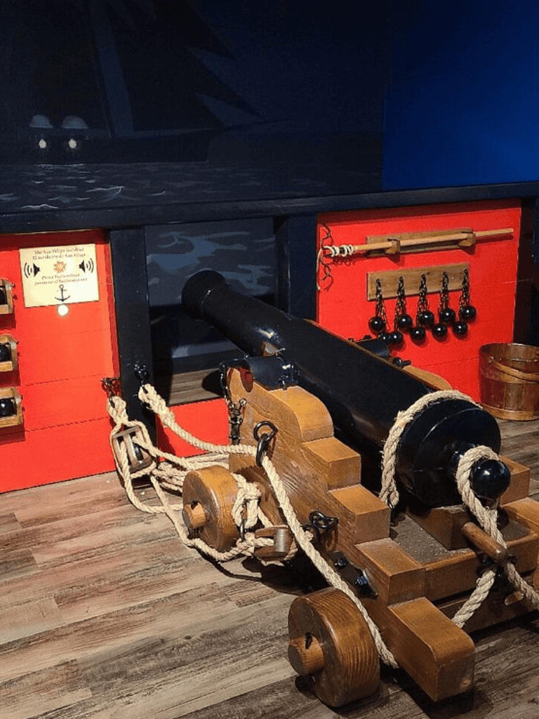 1. Vintage toy cannon on wooden wheels at QuestForDirections exhibit.