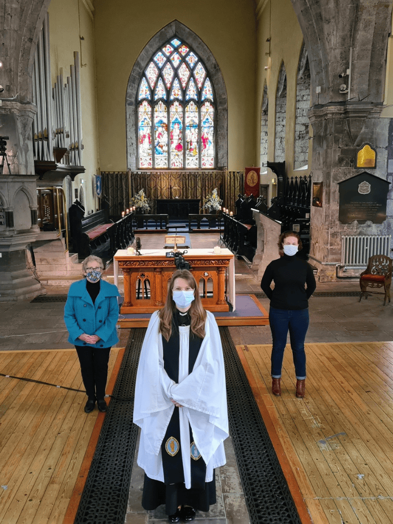 Graceful church interior with stained glass window, clergy and assistants during service, evoking spiritual guidance and community.