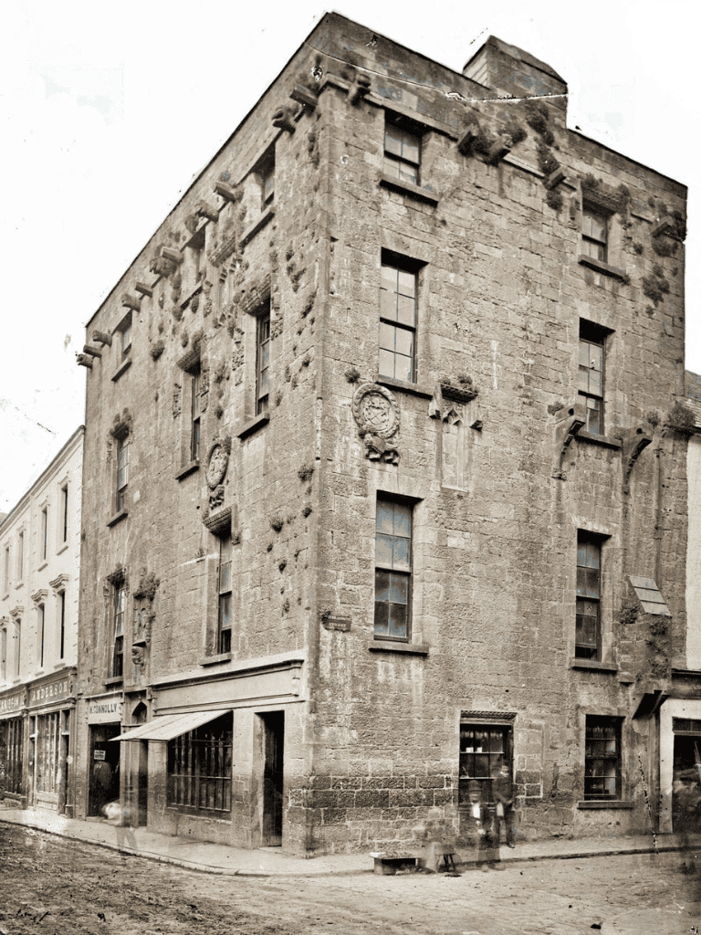 Weathered historic stone building on city street, vintage architecture, old-world charm, urban environment, Quest for Directions.