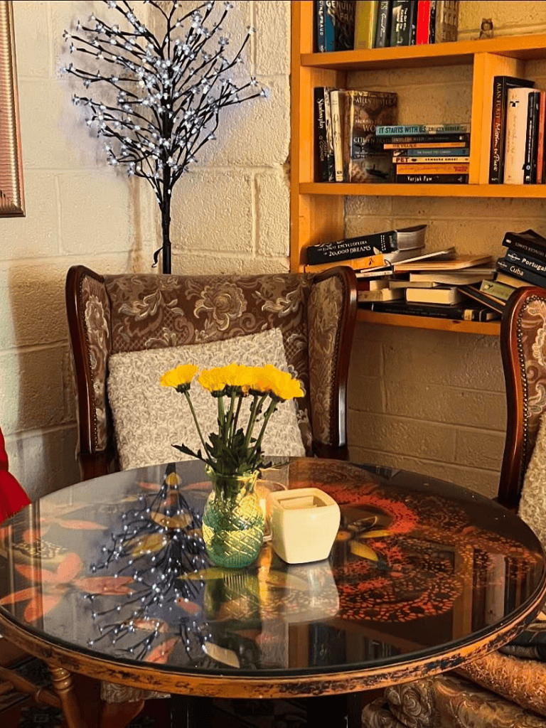 Colorful cozy reading nook with vintage armchair, bookshelf, and decorative lamp in a home library.