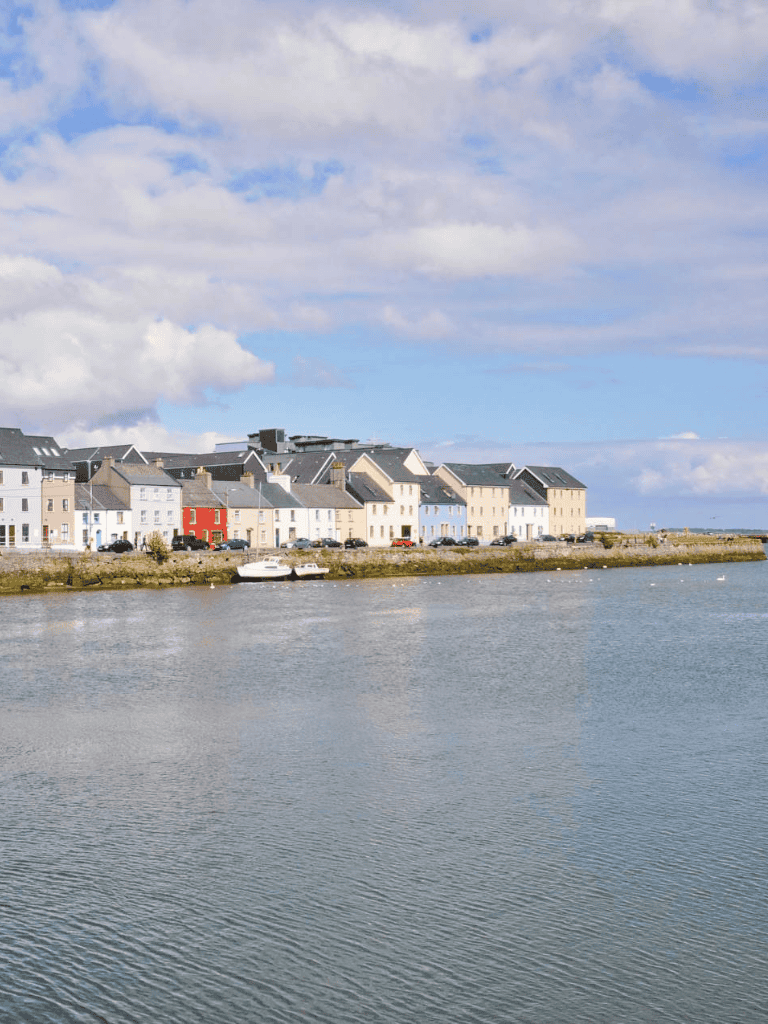 Colorful seaside town with waterfront houses and boats on the water, scenic coastal scenery.