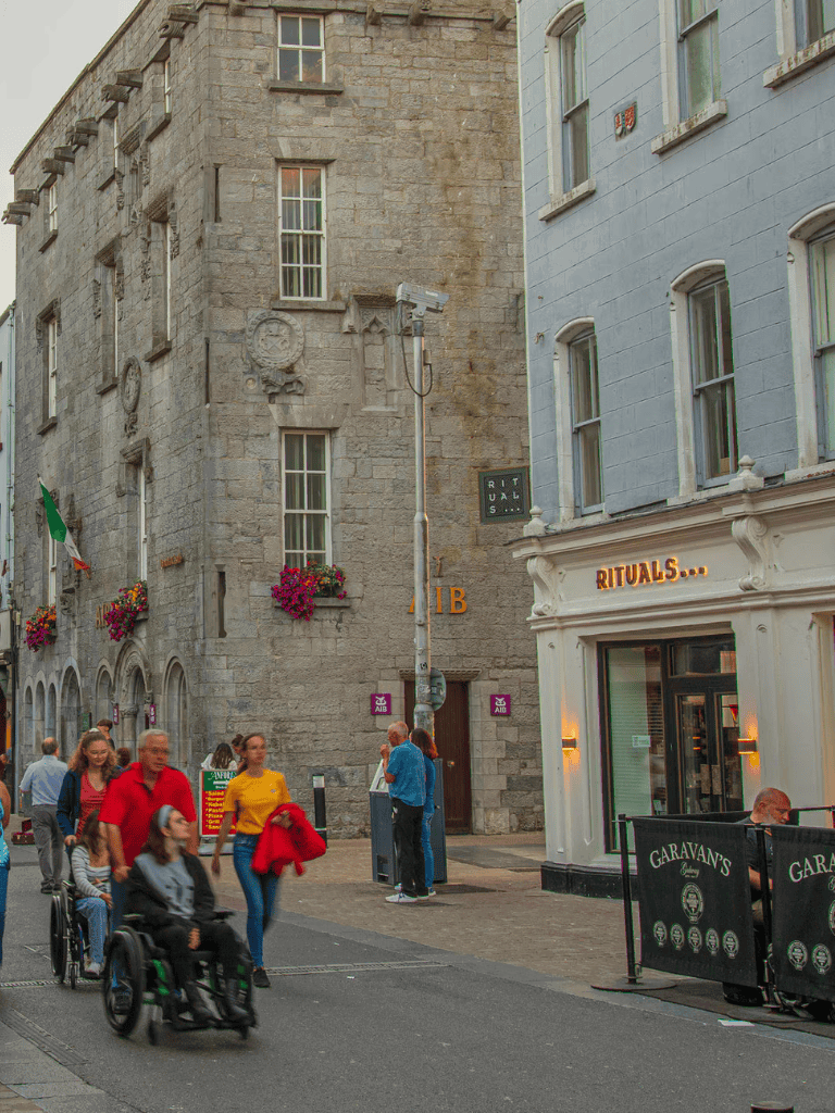 Accessible city street with historic buildings, pedestrians, and outdoor dining, vibrant city atmosphere for urban exploration.