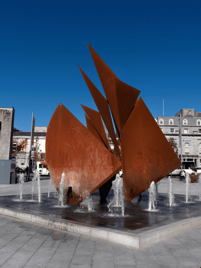 Rusty abstract sculpture fountain in downtown city square.