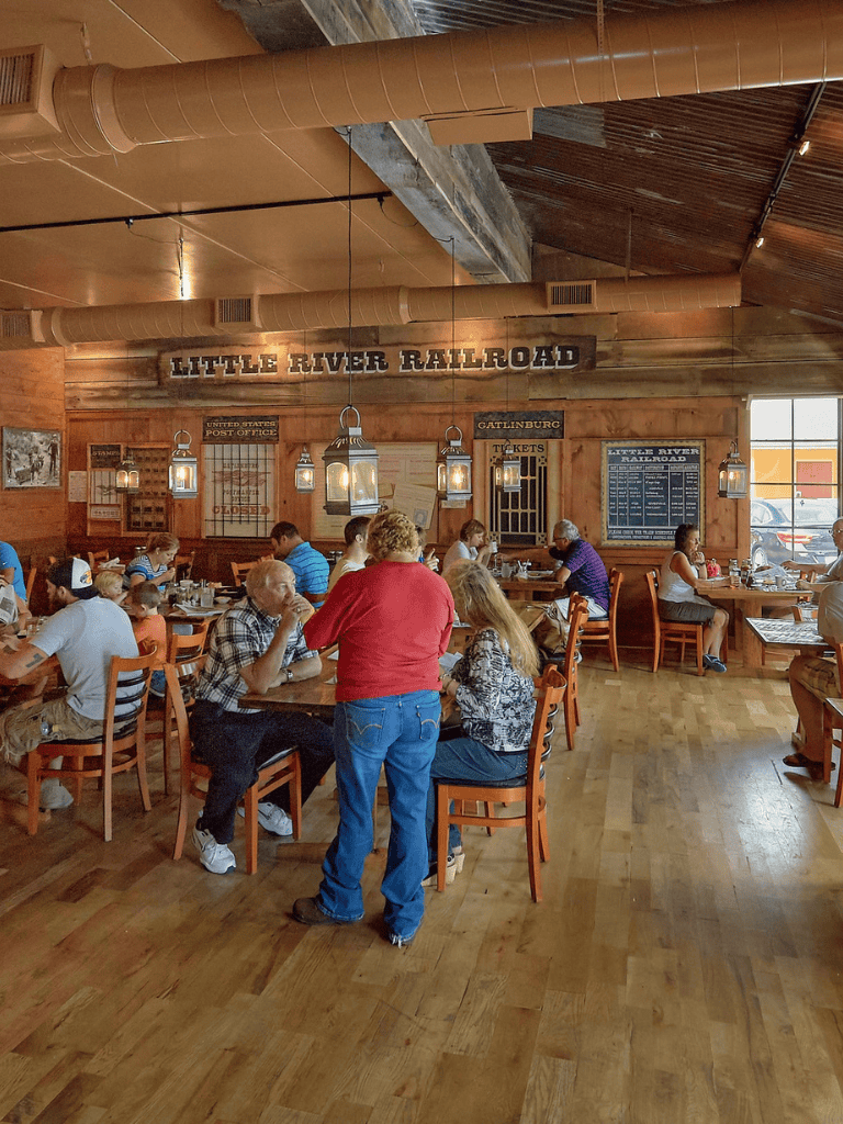 Rustic Little River Railroad restaurant interior with patrons dining and staff service.