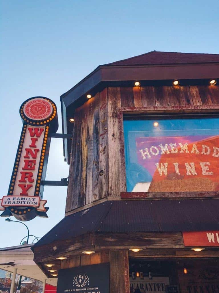 Handmade wine sign at rustic winery with wooden exterior and cozy lighting, showcasing local wine tasting experience.